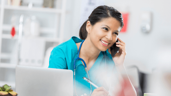 A woman smiling while on a phone call